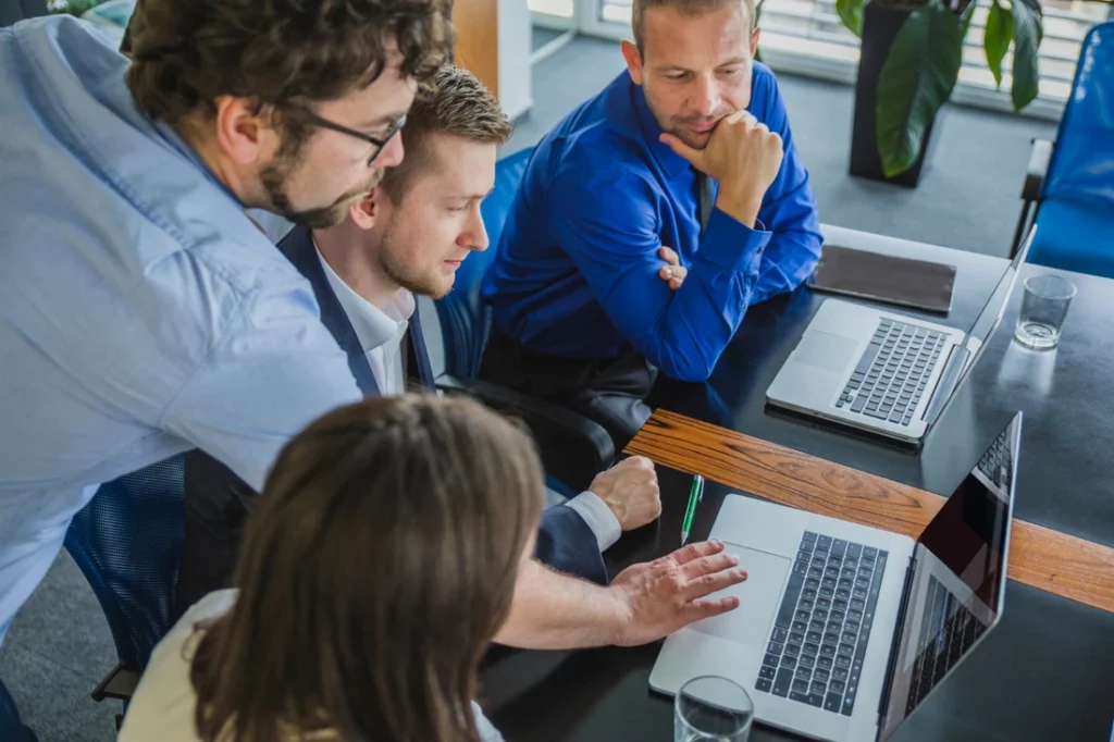 Professionnels réunis autour de leurs ordinateurs pour examiner un projet